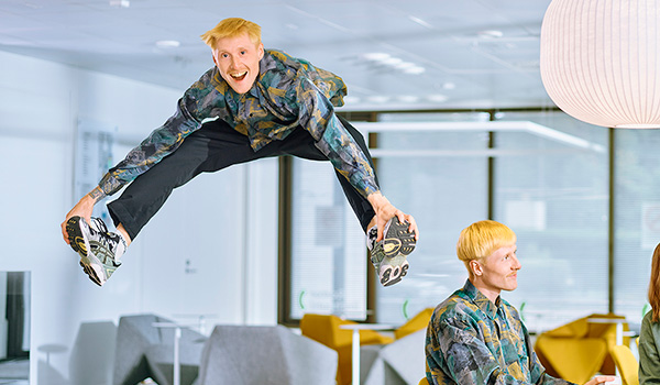 Kuvassa on ilmaan hyppäävä iloinen opiskelija.